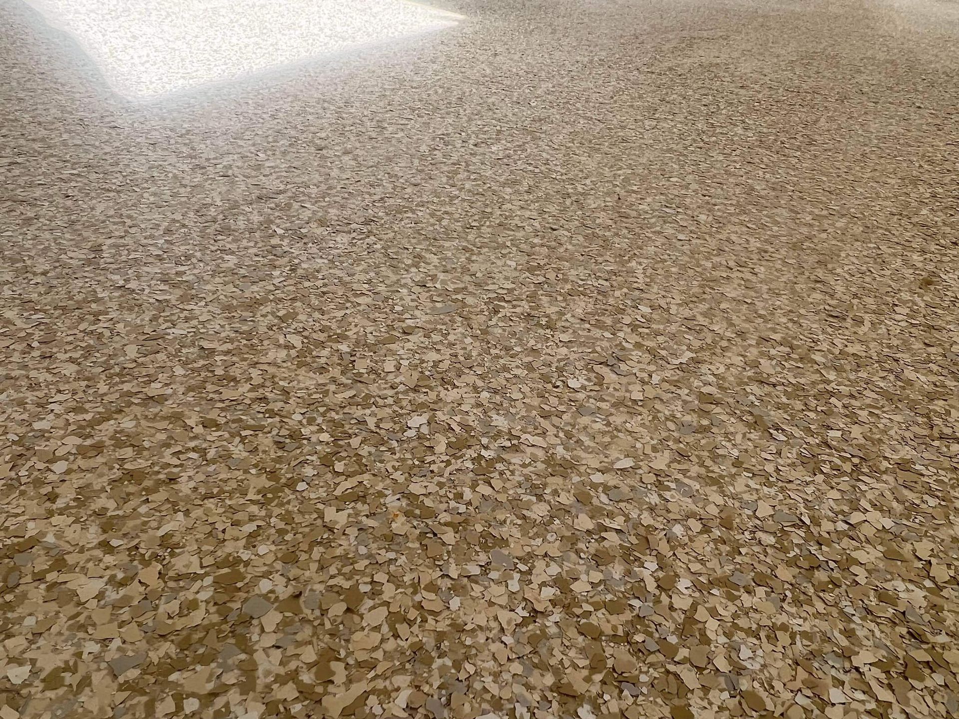 Speckled beige flooring with light and dark flakes.