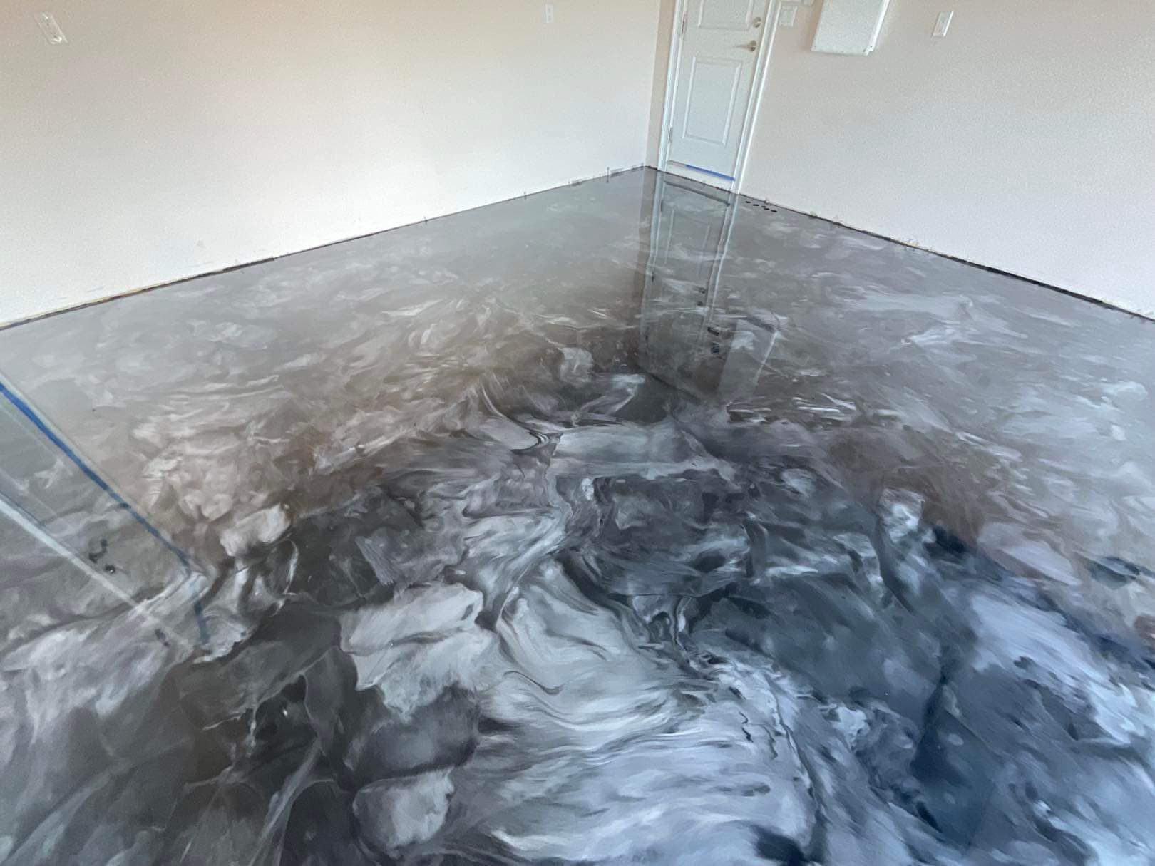 Metallic epoxy garage floor, swirls of silver, gray, and black.