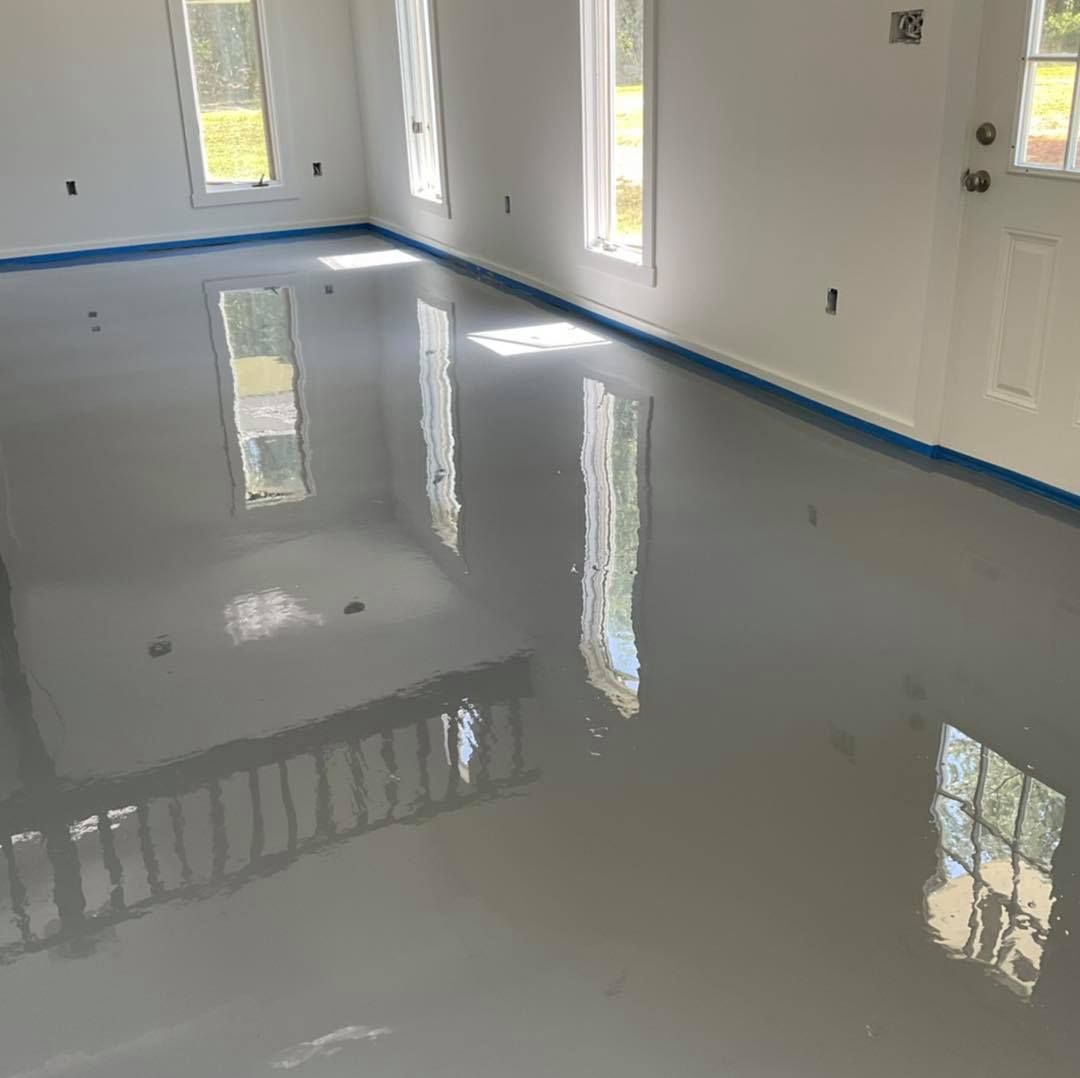 A room with a smooth, gray epoxy floor reflecting light from windows.