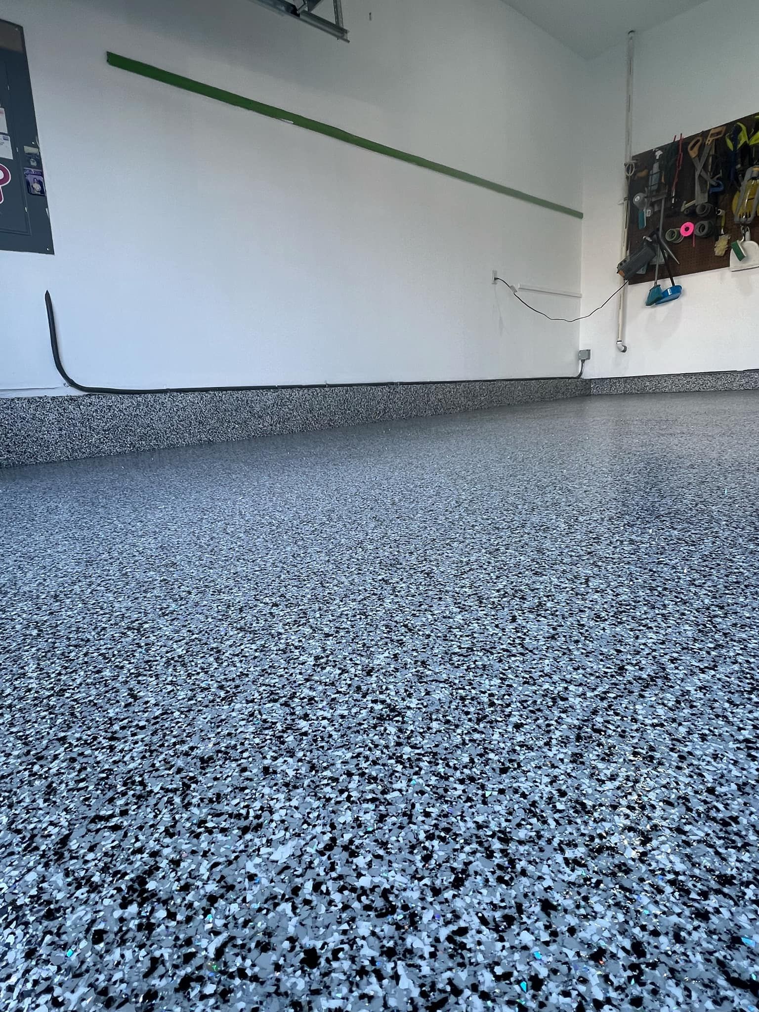 Garage interior with speckled epoxy floor, white walls, and black trim.