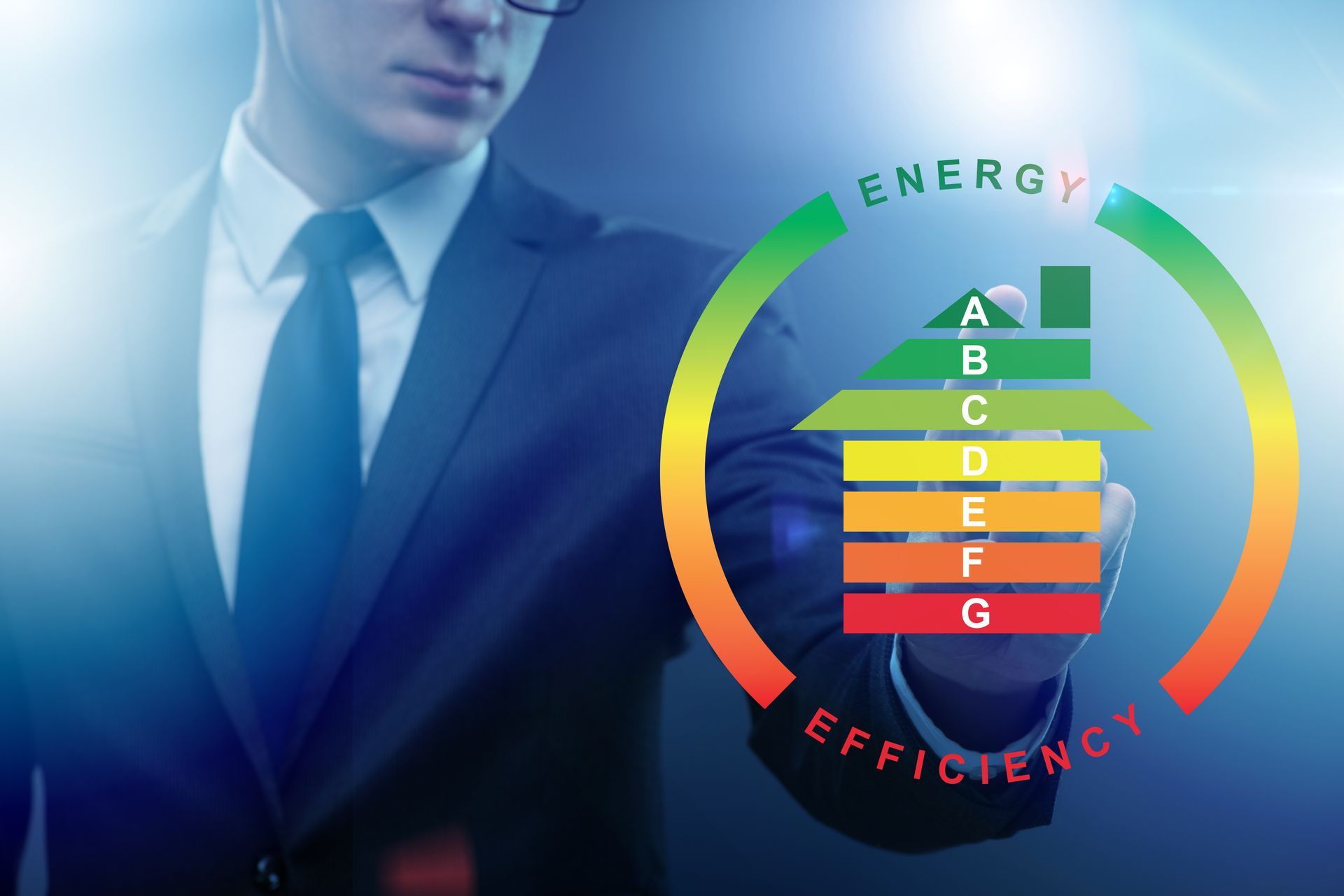 Un uomo d'affari indica un grafico dell'efficienza energetica a forma di casa, che mostra le classificazioni da A (verde) a G (rosso).