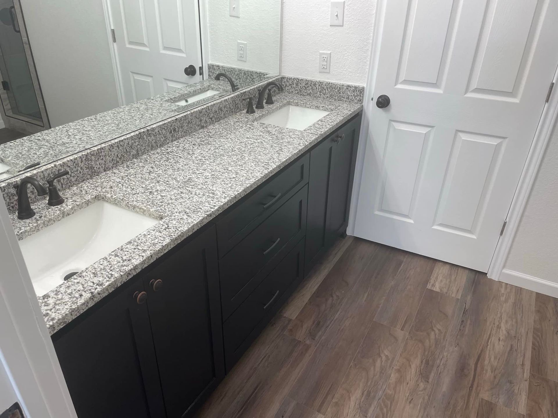 A bathroom with two sinks and a large mirror.