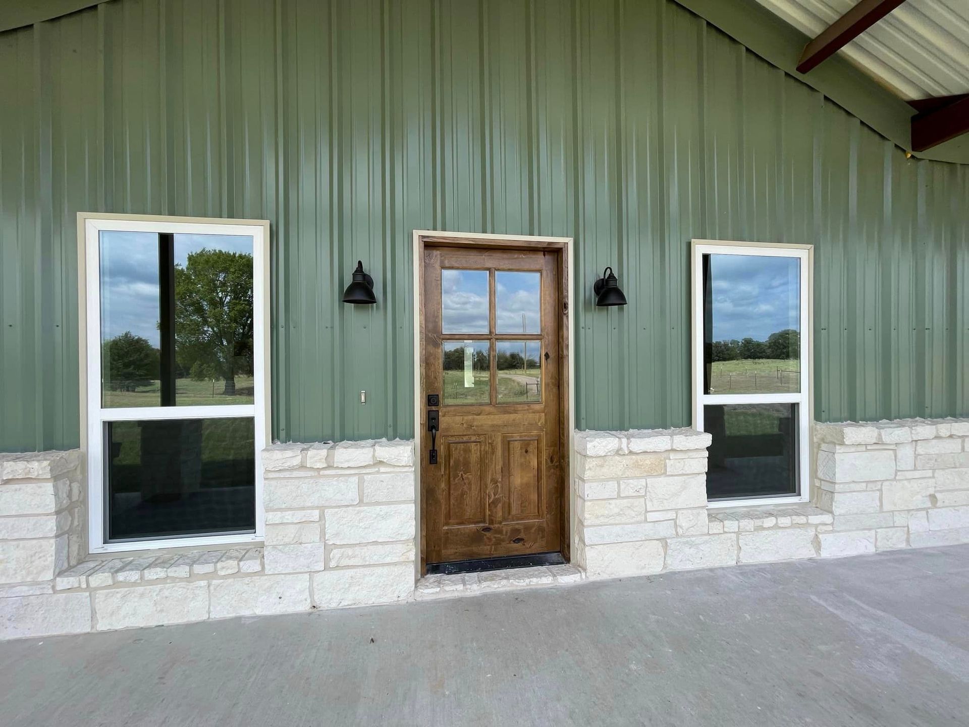 A green building with a wooden door and windows