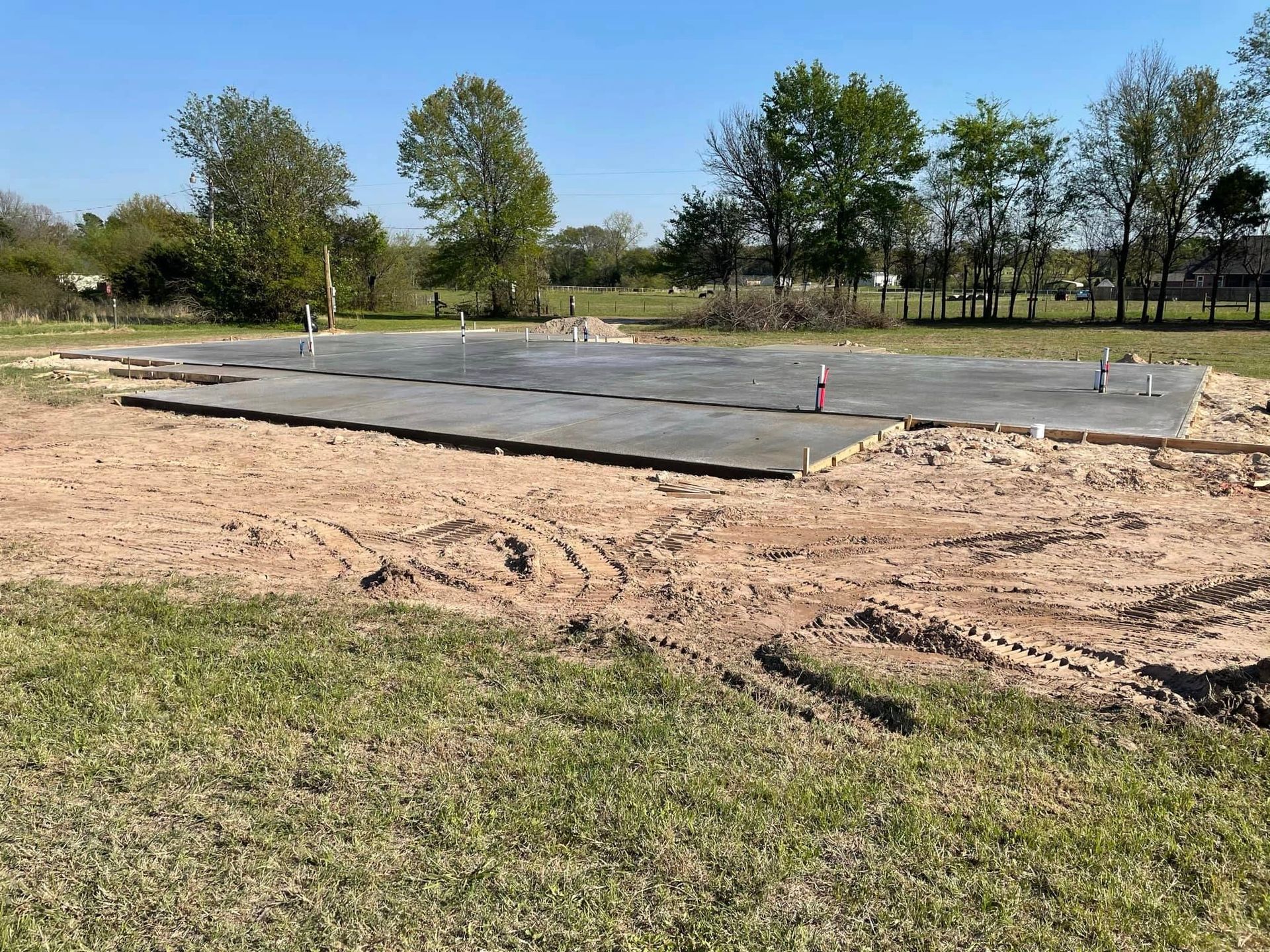 A large concrete slab is sitting in the middle of a grassy field.