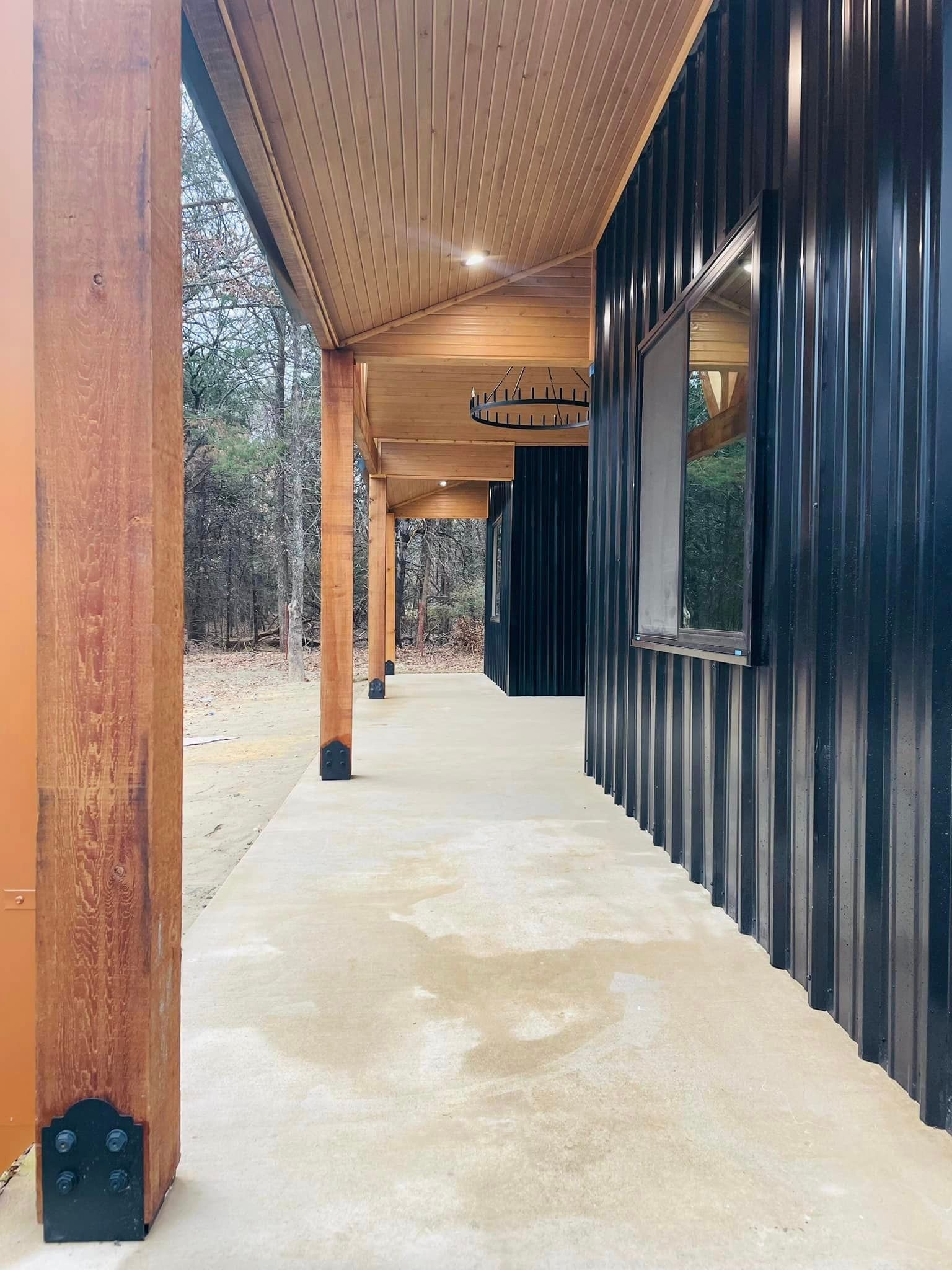 A long walkway leading to a black building with a window