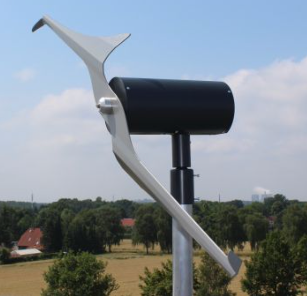 A wind turbine is sitting in the middle of a field