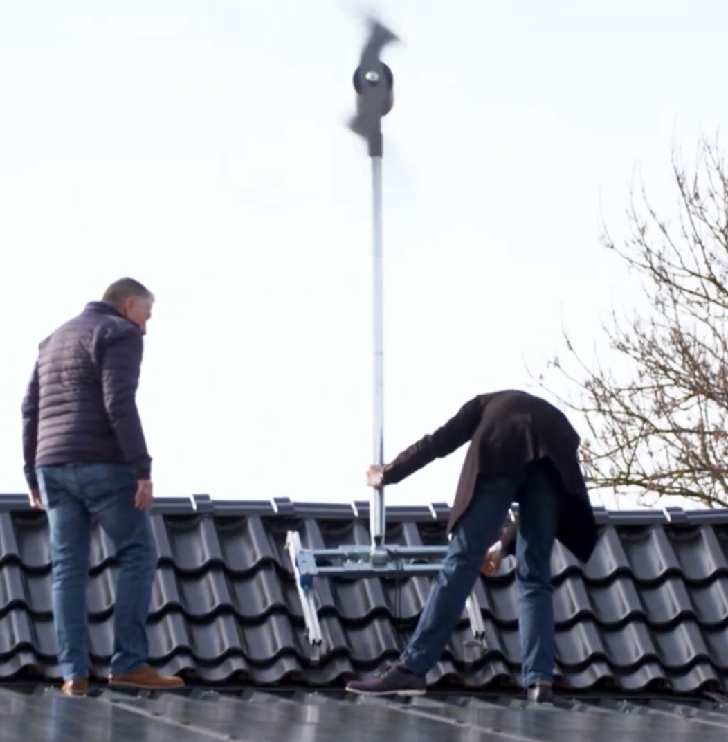 Two men are working on the roof of a building