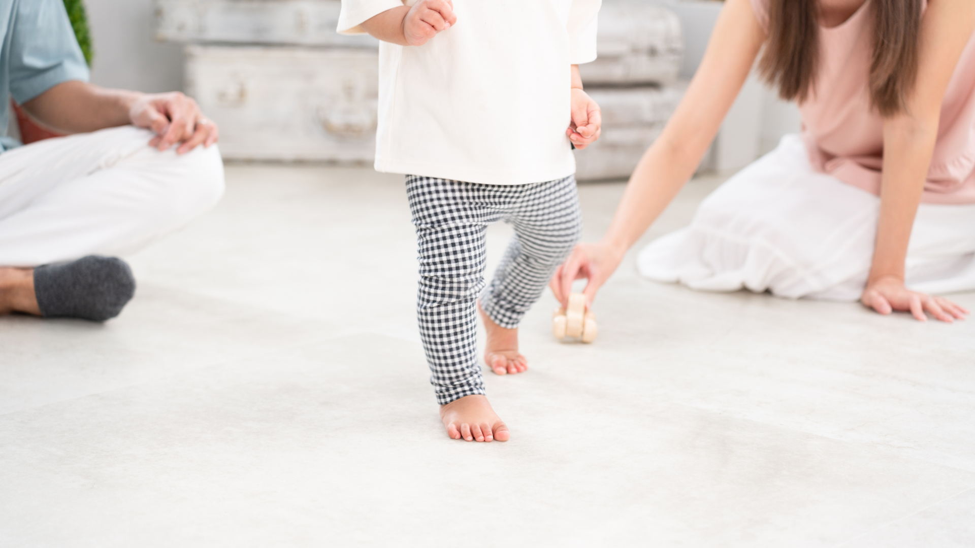A family is playing with a baby on the floor.