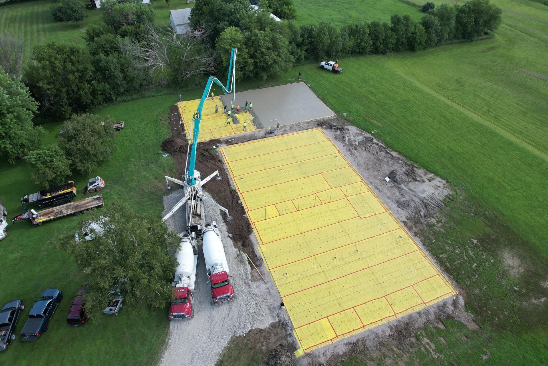An aerial view of a construction site with trucks and a crane.