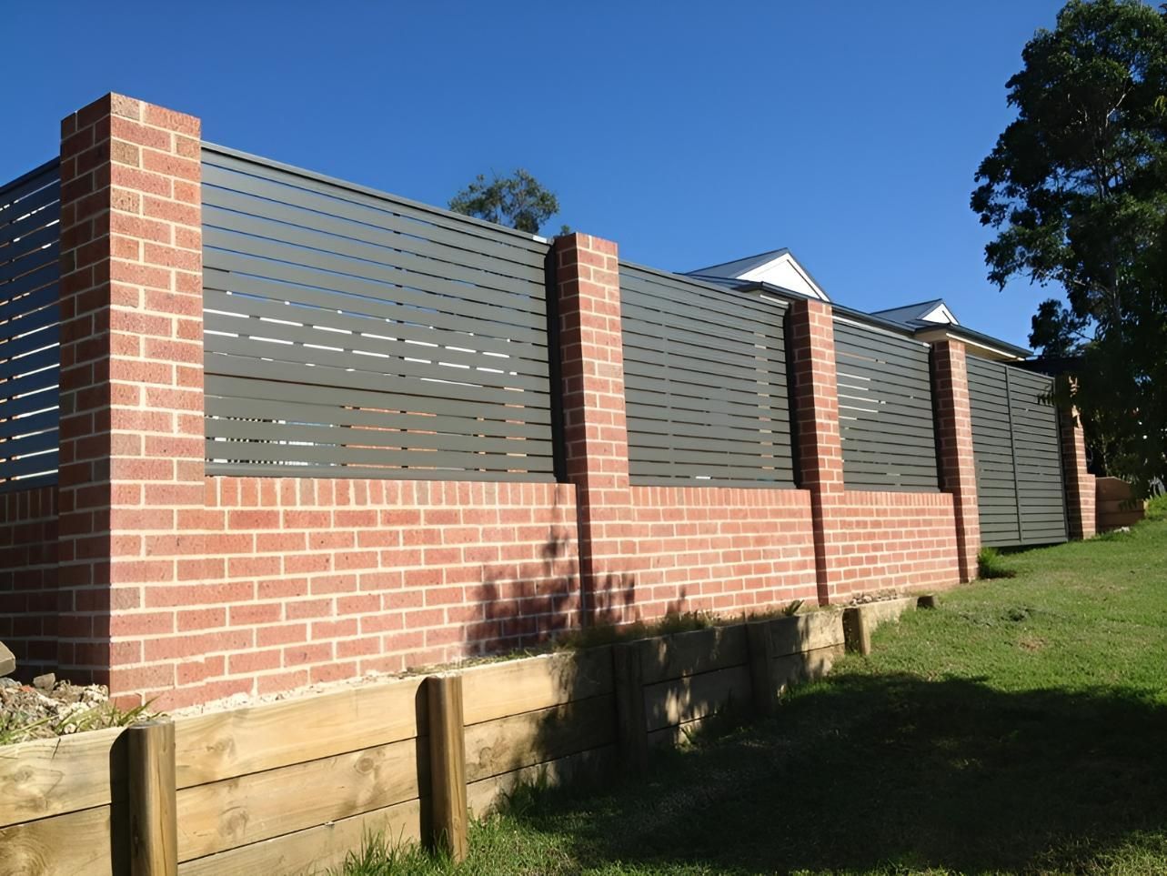 A Brick Wall With a Metal Fence Surrounding It — Hunter Valley Lattice in Cessnock, NSW
