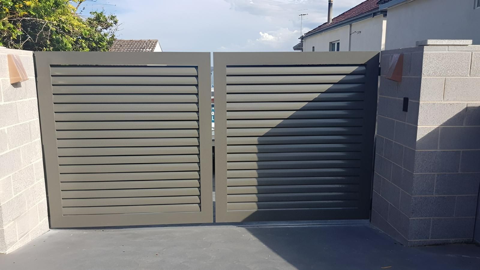 A Gray Gate is Sitting Next to a Brick Wall — Hunter Valley Lattice in Cessnock, NSW