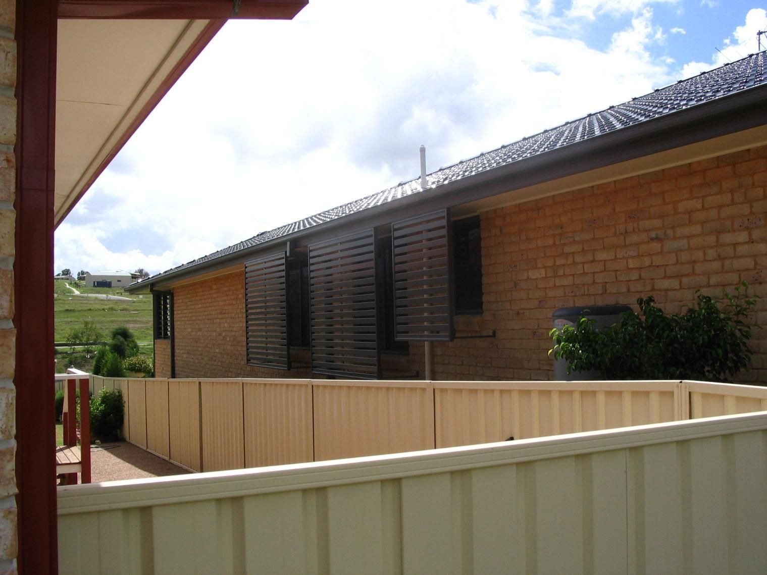 A Brick House With a White Fence in Front of It — Hunter Valley Lattice in Kurri Kurri, NSW