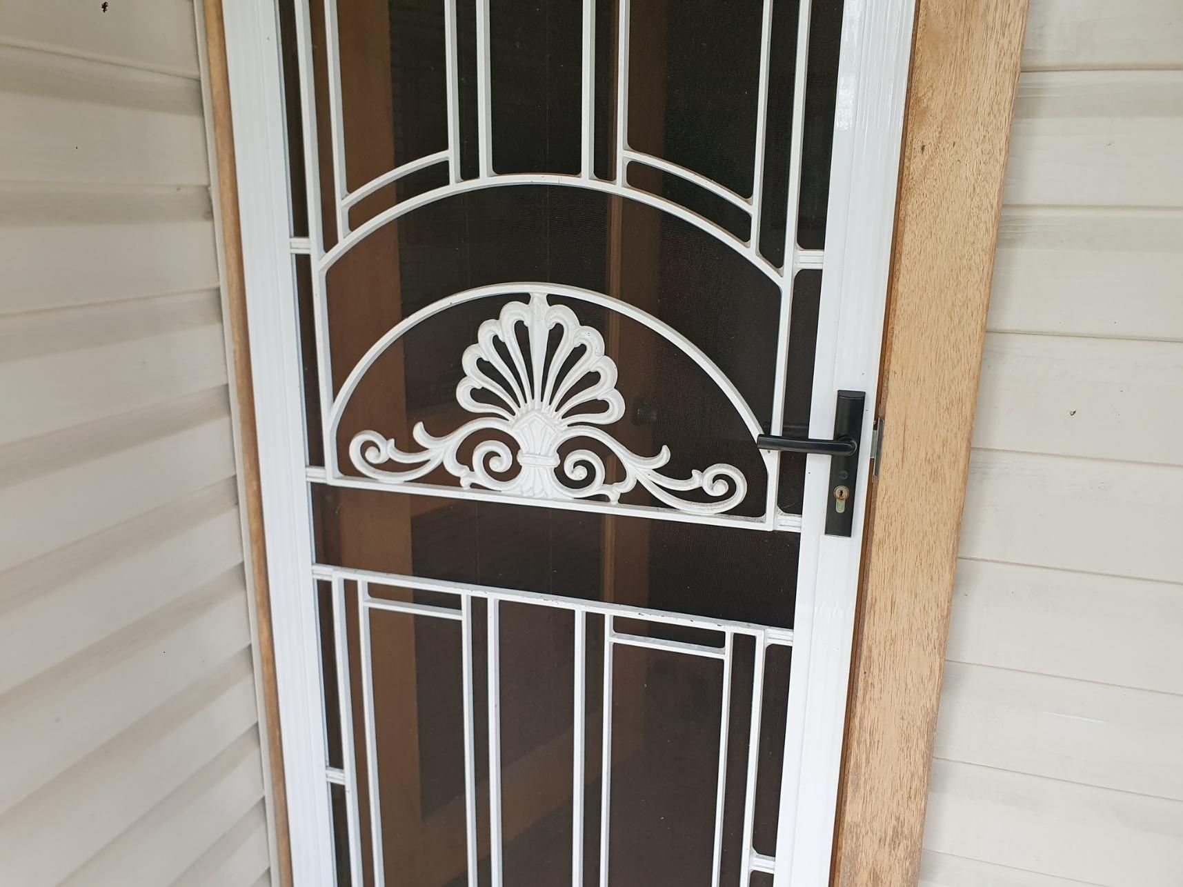 A White Screen Door With a Wrought Iron Design on It — Hunter Valley Lattice in Port Stephens, NSW
