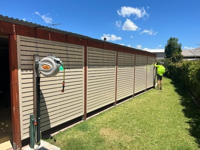 A Man is Standing in Front of a Fence in a Yard — Hunter Valley Lattice in Lake Macquarie, NSW