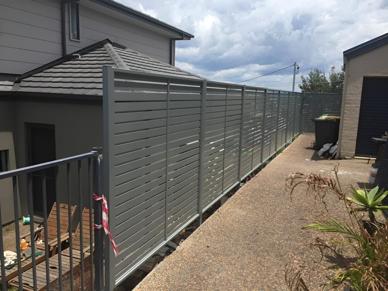 A Fence is Surrounding a Sidewalk in Front of a House — Hunter Valley Lattice in Kurri Kurri, NSW