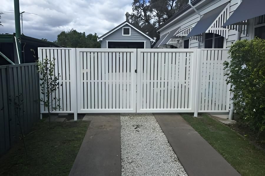 A White Fence Surrounds a Driveway Leading to a House — Hunter Valley Lattice in Kurri Kurri, NSW