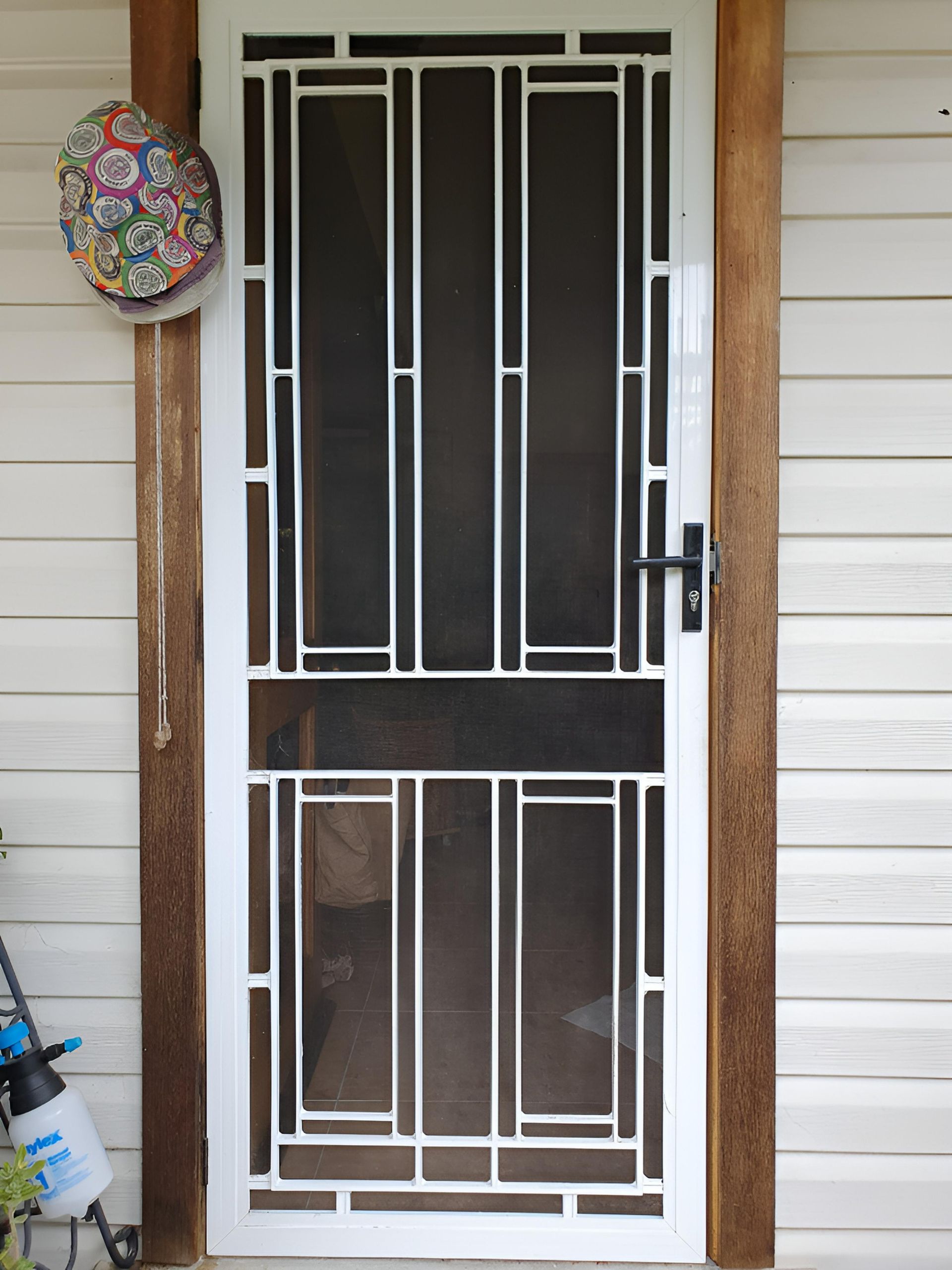 A White Screen Door is Sitting on a Brick Wall — Hunter Valley Lattice in Newcastle, NSW