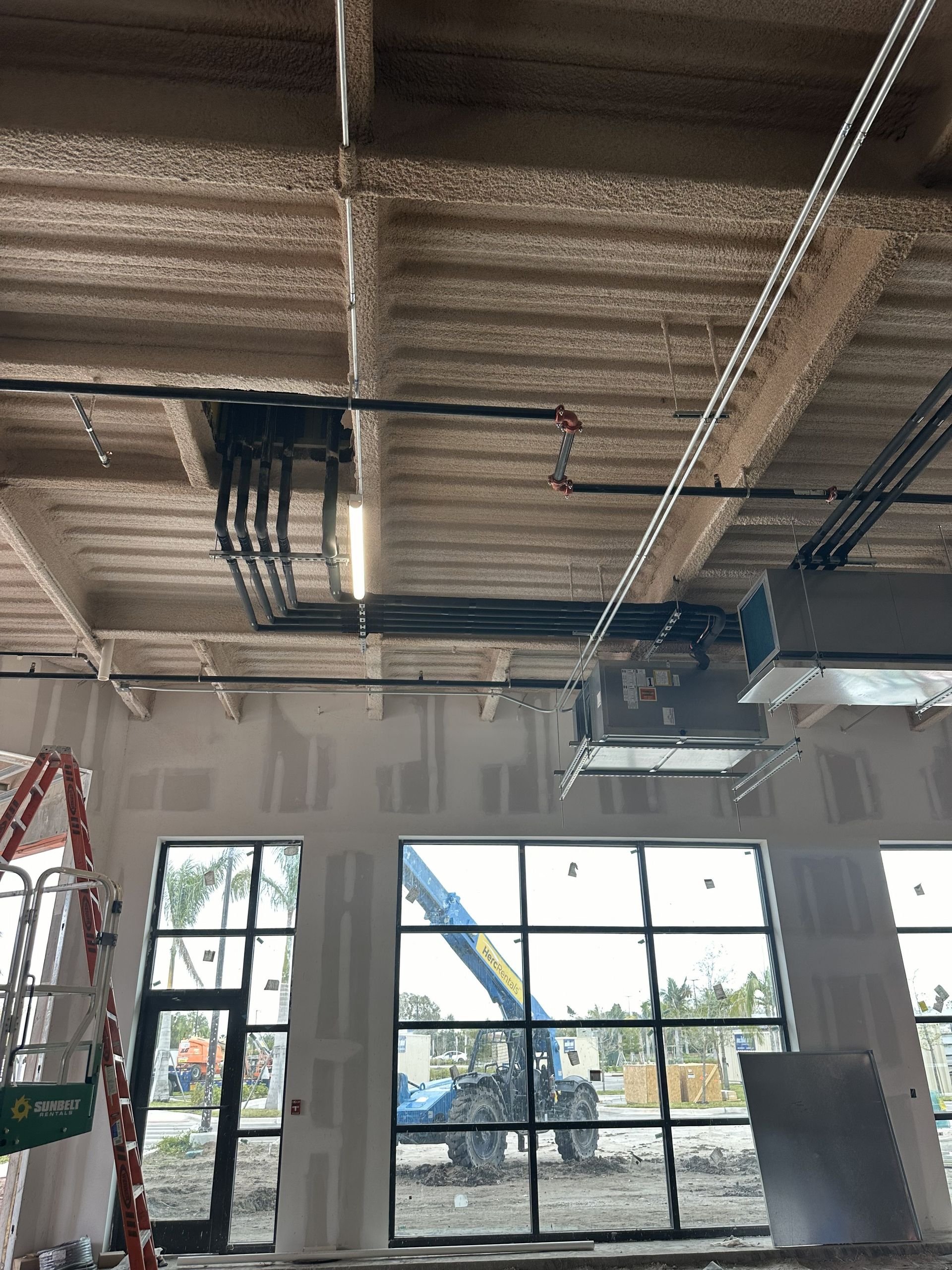 Interior of a building under construction. Exposed ceiling with conduit and ventilation.