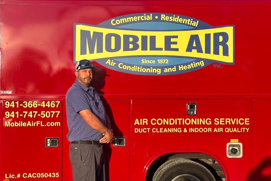Man standing by red Mobile Air truck; company logo and service information visible.