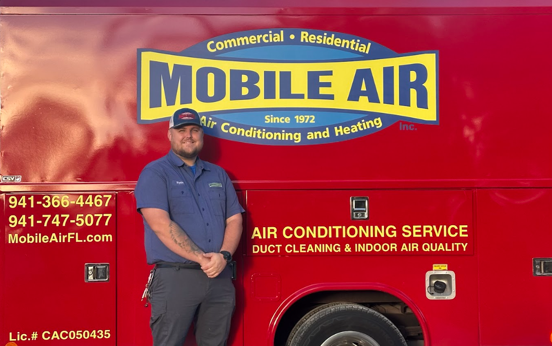 Man stands next to a red Mobile Air truck. The truck has the company logo and contact info on it.
