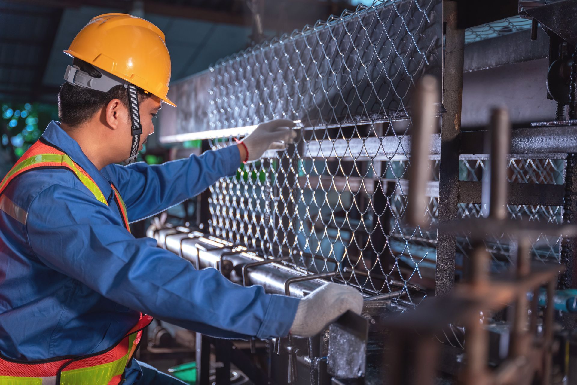 A technician is working on a production machine for steel wire mesh for construction work.
