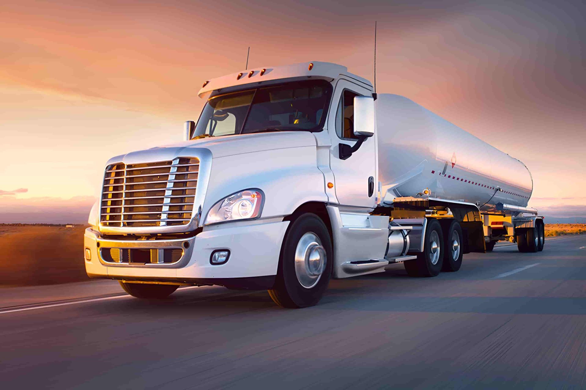 A White Semi Truck Is Driving Down A Highway At Sunset — Raymond Terrace Windscreen Services In Port Stephens, NSW