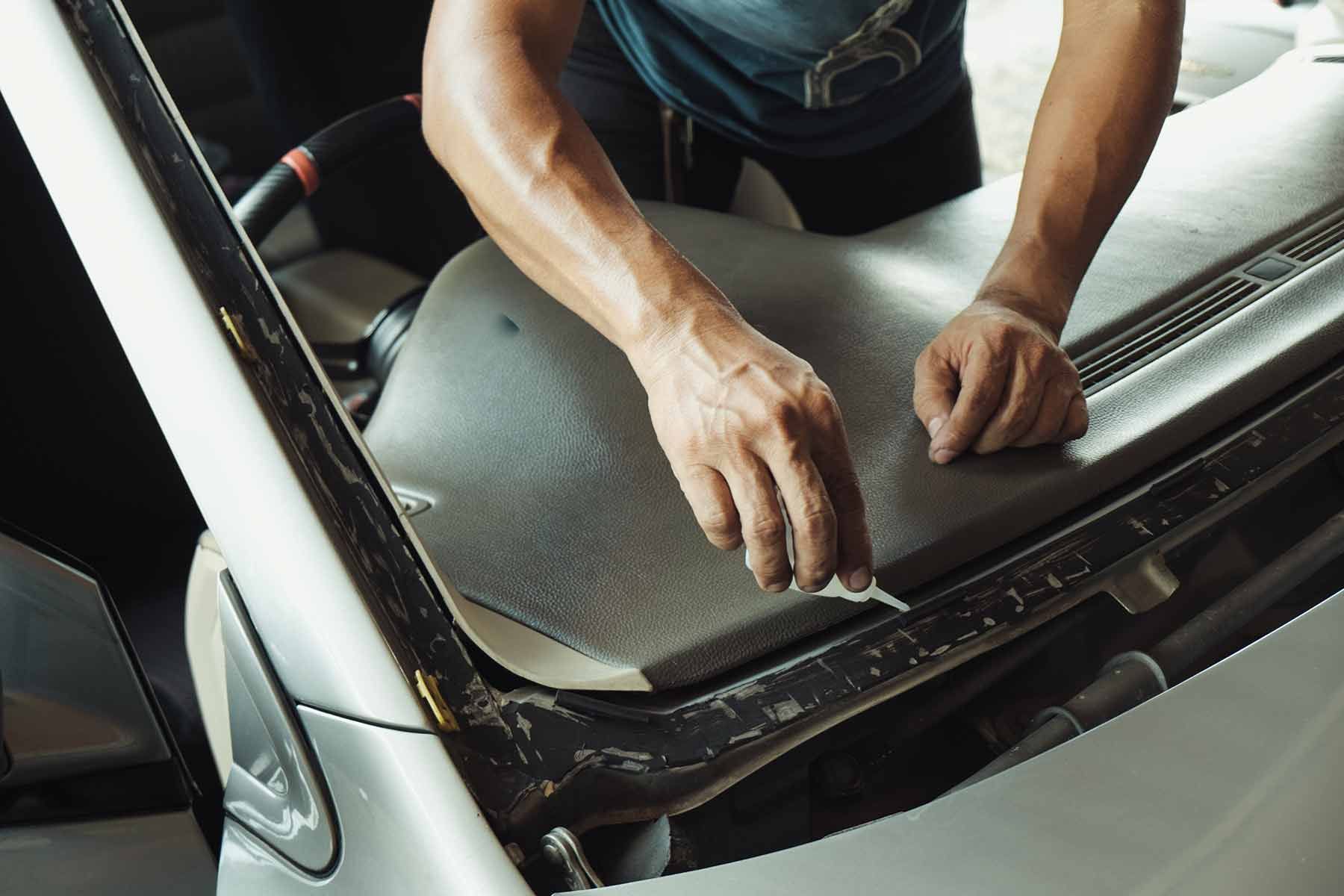 Two Men Are Working On A Windshield In A Garage — Raymond Terrace Windscreen Services In Newcastle, NSW