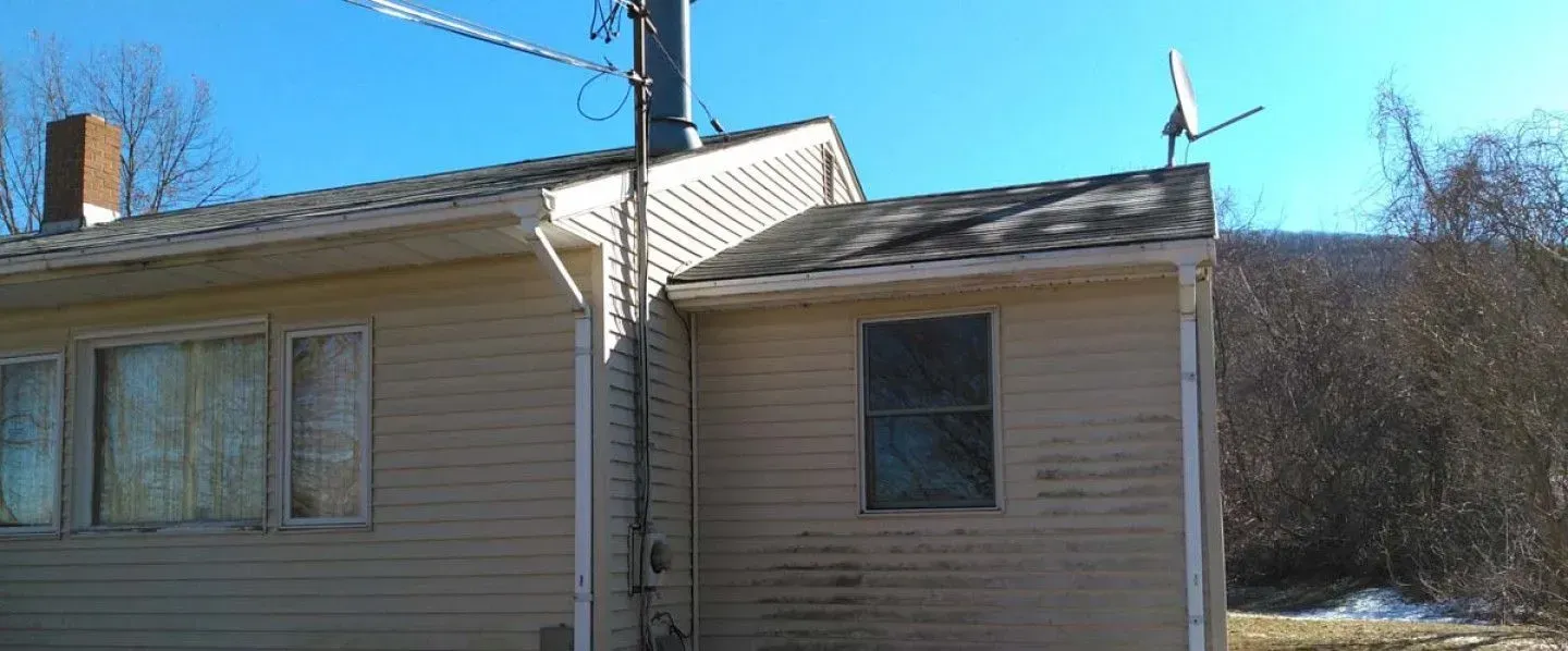 A small house with a chimney on the roof and a window.