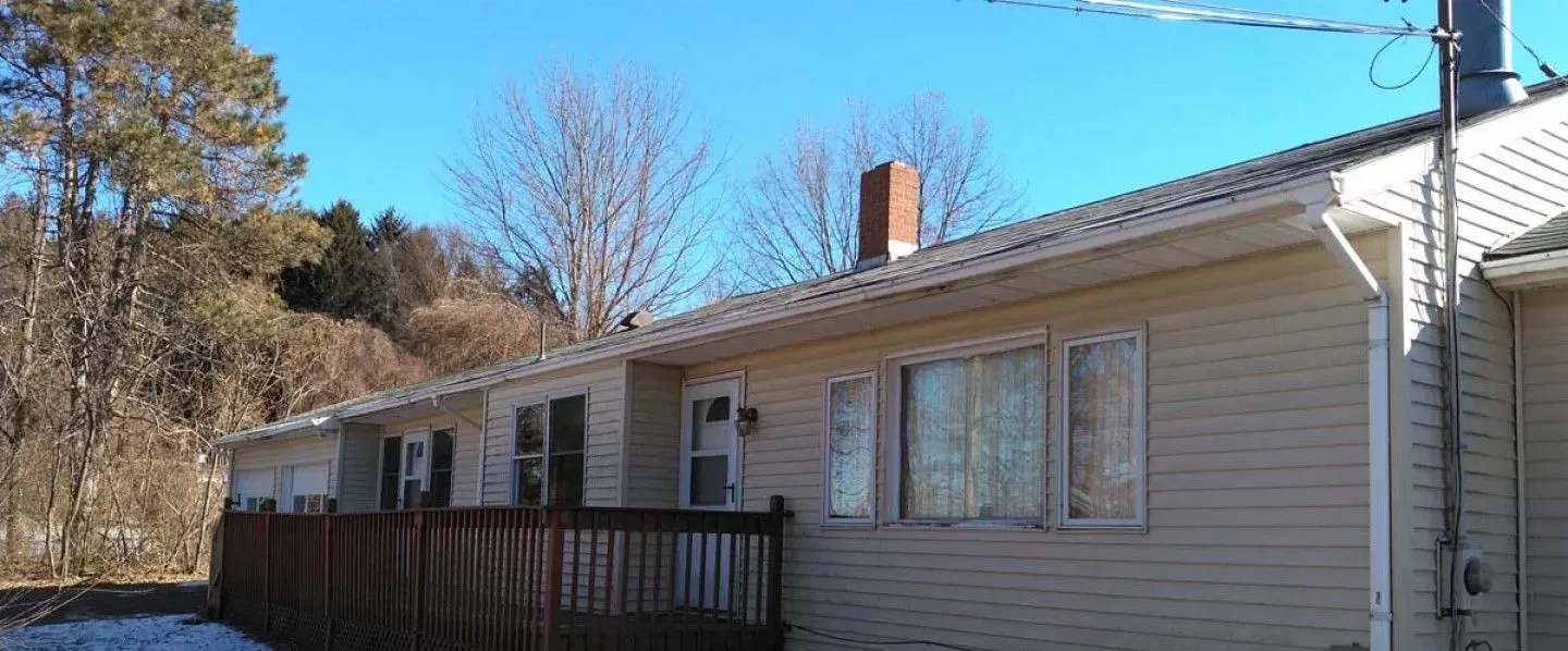 A house with a lot of windows and a chimney on the roof.
