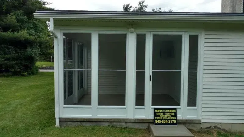 A screened in porch with a sign on the side of it.