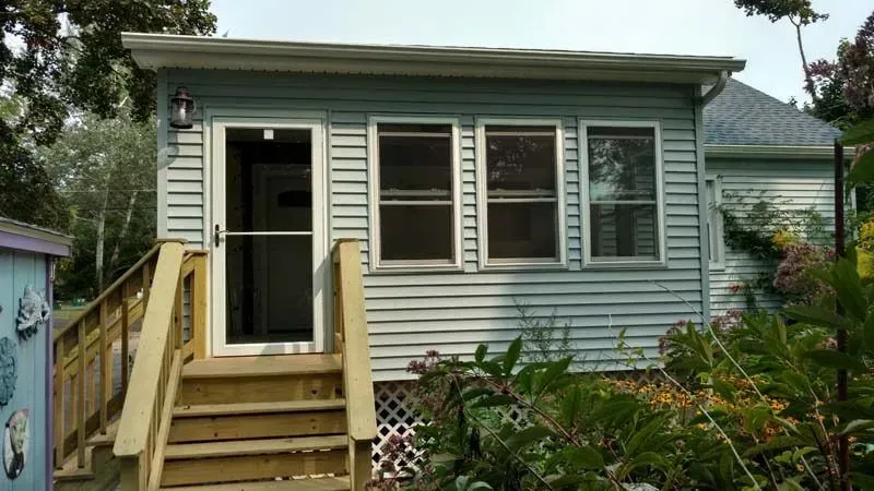 A small house with a wooden deck and stairs
