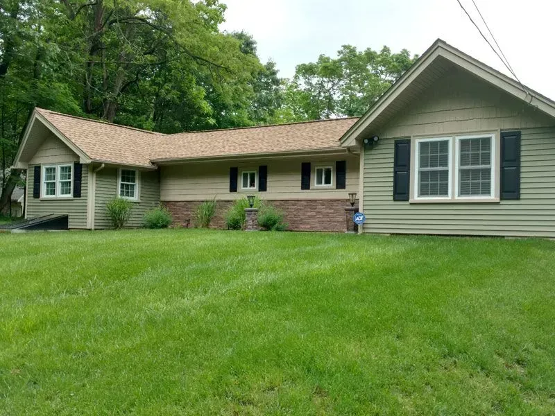 A house with a large lawn in front of it