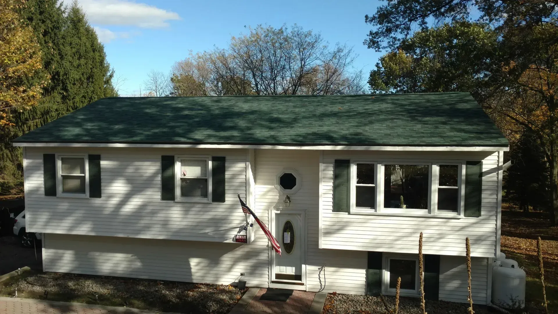 A white house with a green roof and black shutters