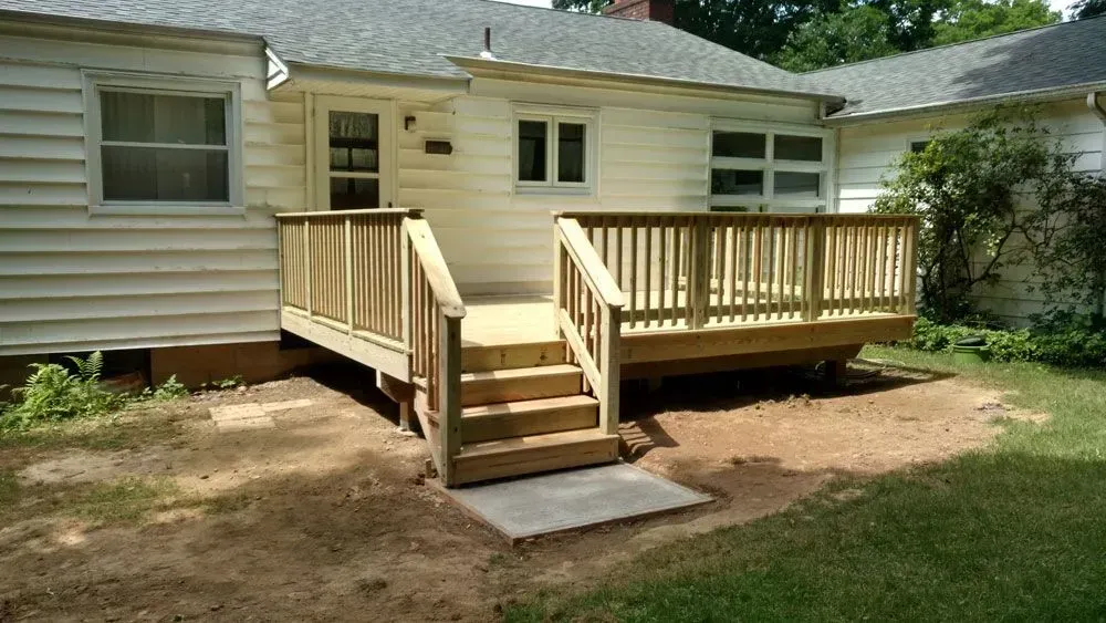 A white house with a wooden deck in front of it