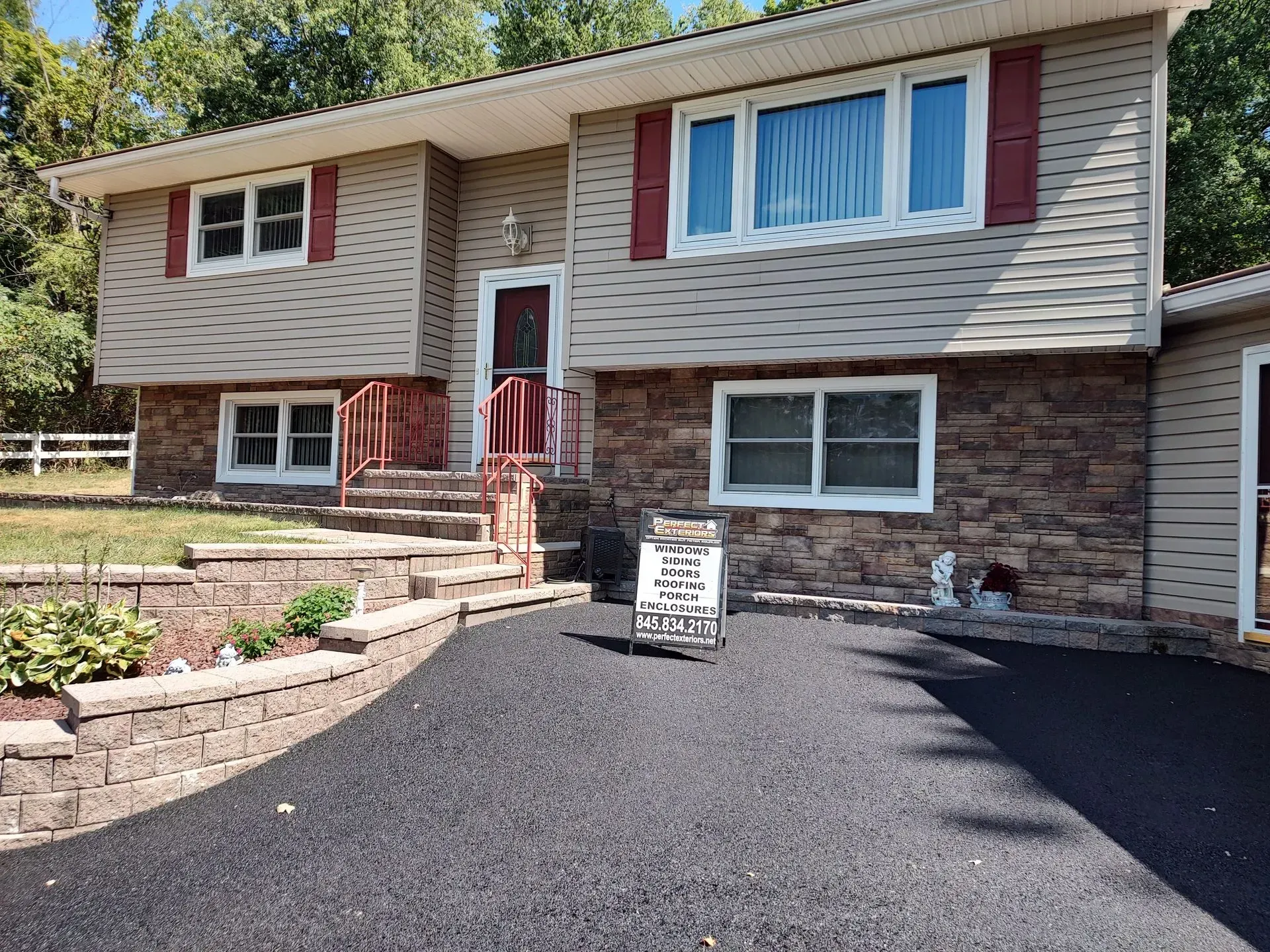 A large house with a black driveway in front of it.