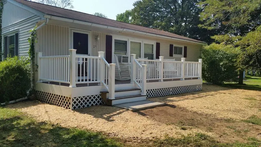 A small white house with a white porch and stairs.