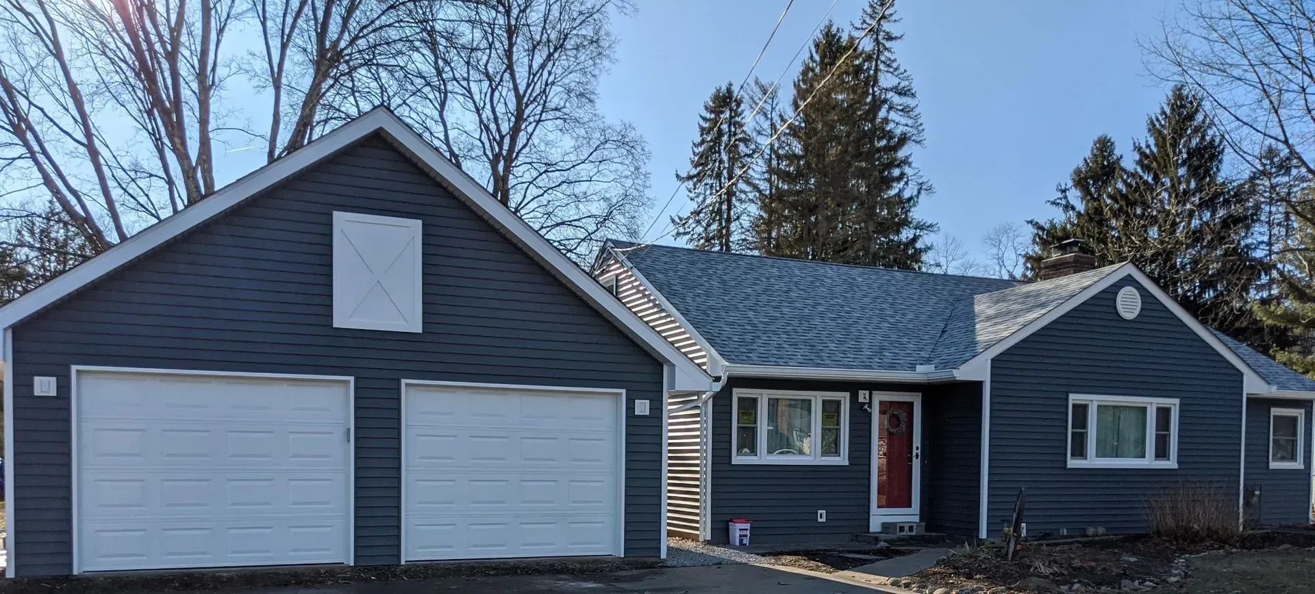 A house with a garage attached to it and a blue sky in the background.