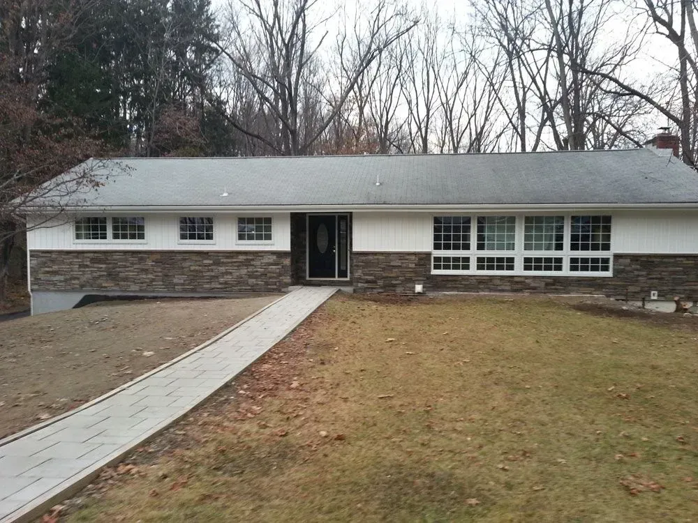A house with a gray roof and a stone facade