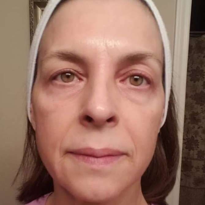 A close up of a woman 's face with a headband on her head.