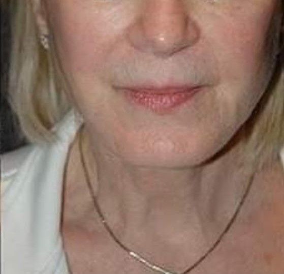 A close up of a woman 's face wearing a necklace.