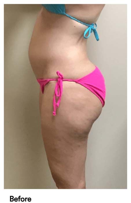 A woman in a pink bikini is standing in front of a white wall.