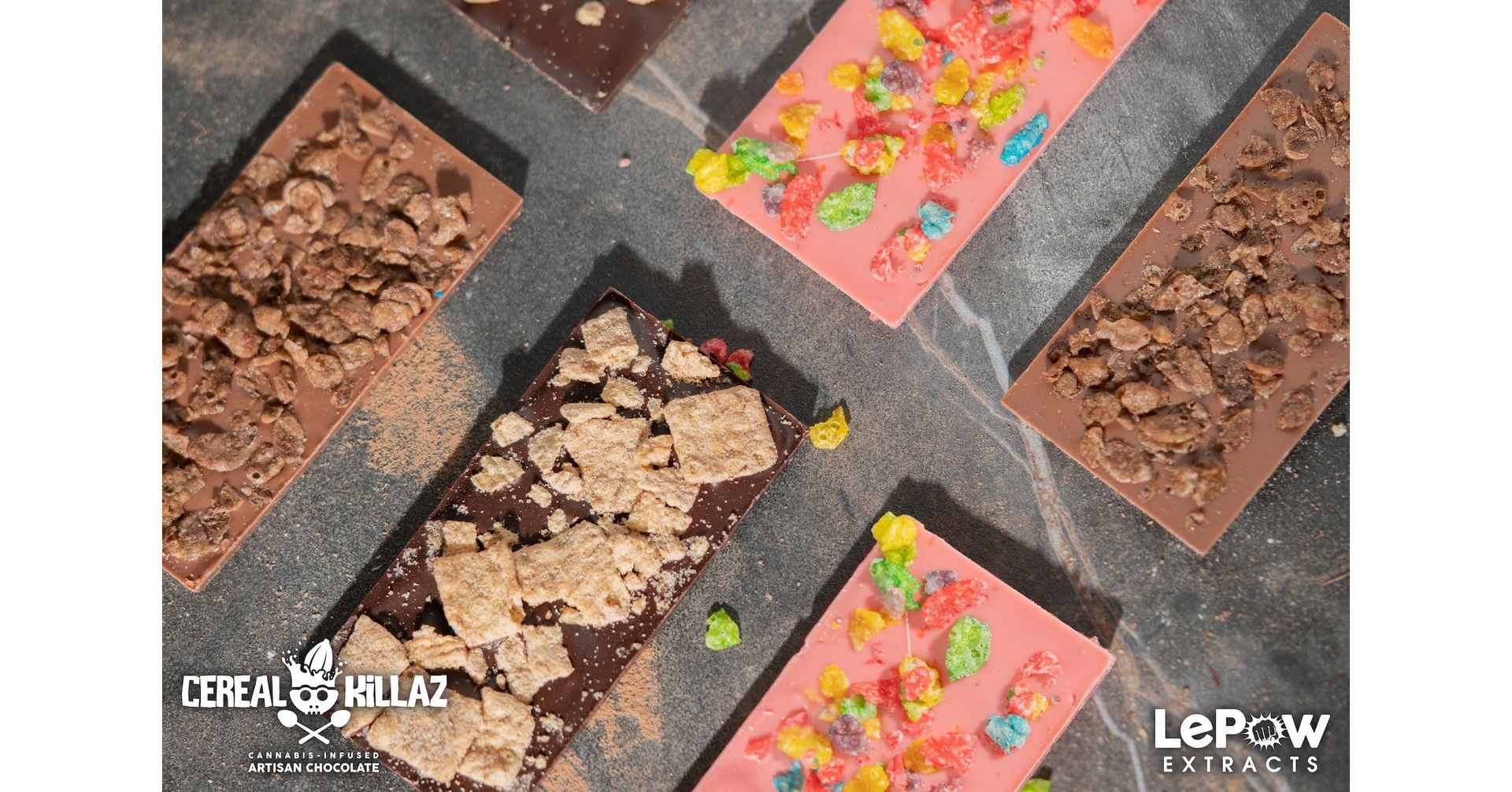 A variety of chocolate bars with cereal on them are sitting on a table.