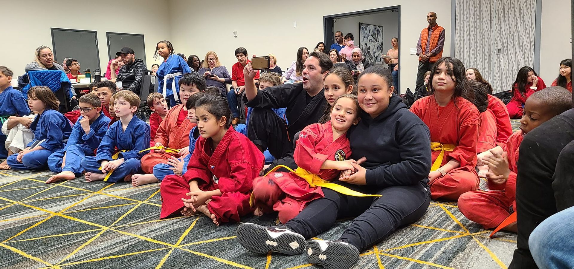 a group of children are sitting on the floor in a room .