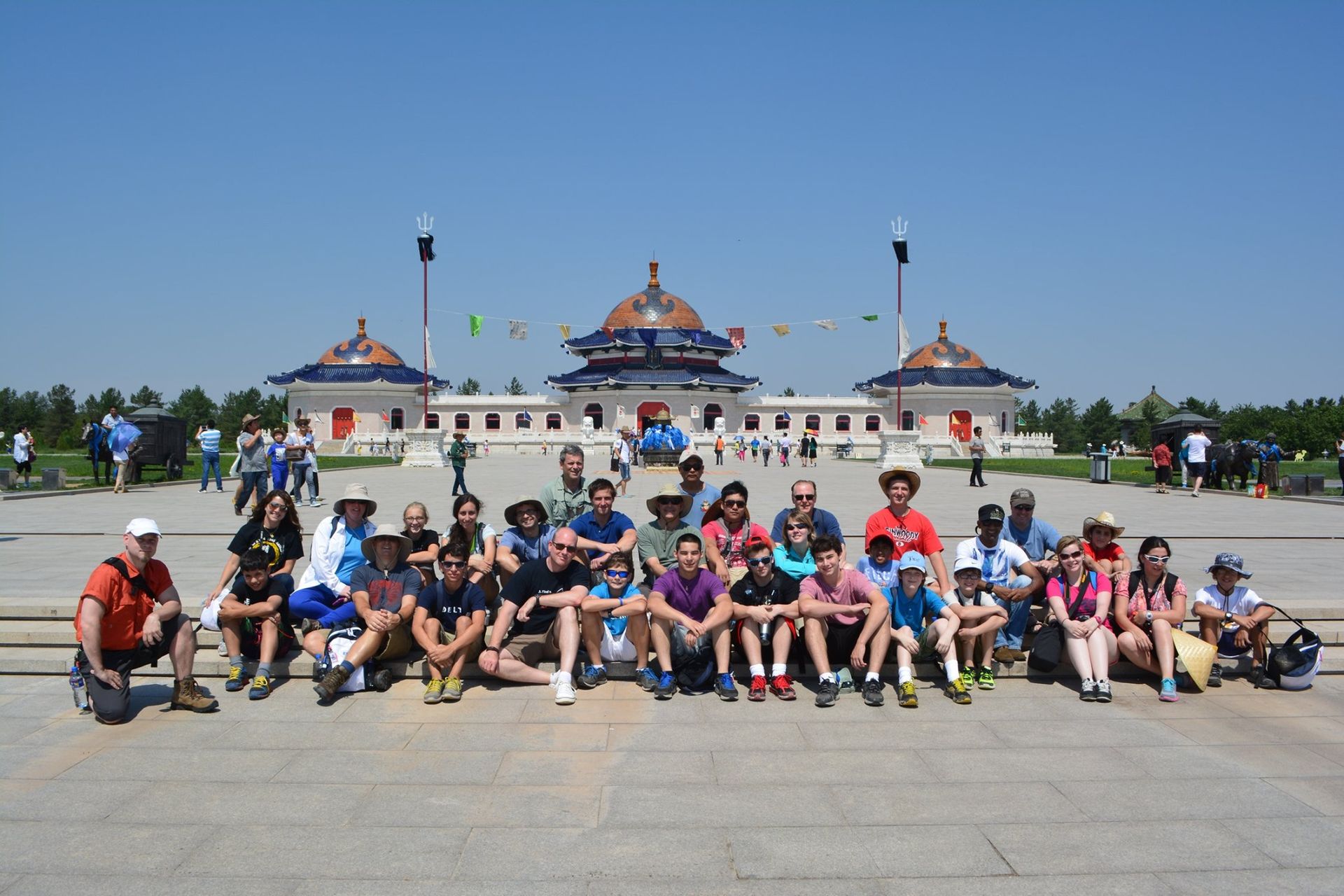 a group of people are posing for a picture in front of a building .