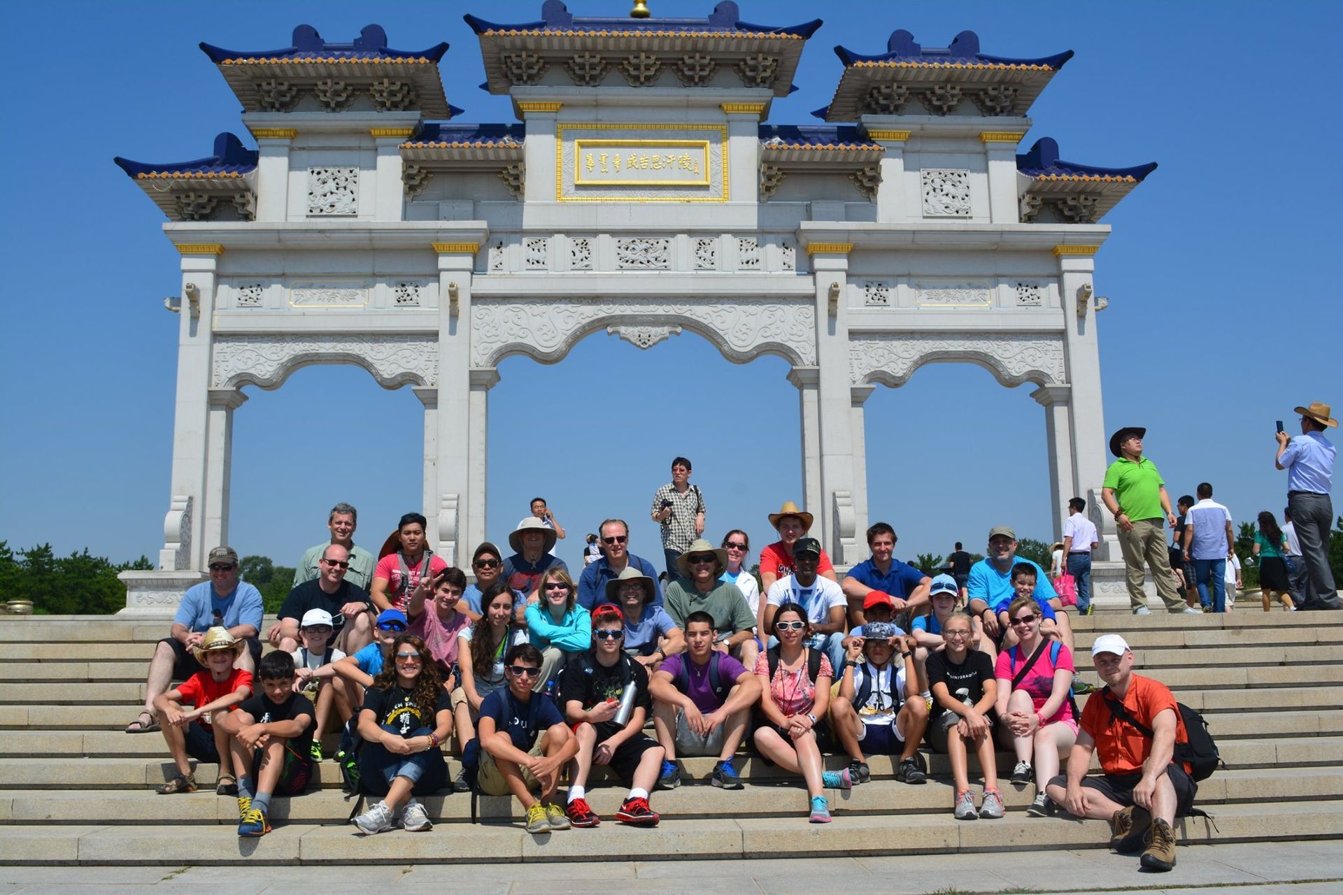 a group of people are posing for a picture in front of a stone archway