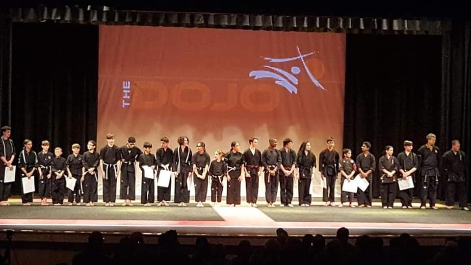 a group of people are standing on a stage in front of a large screen that says the olympics