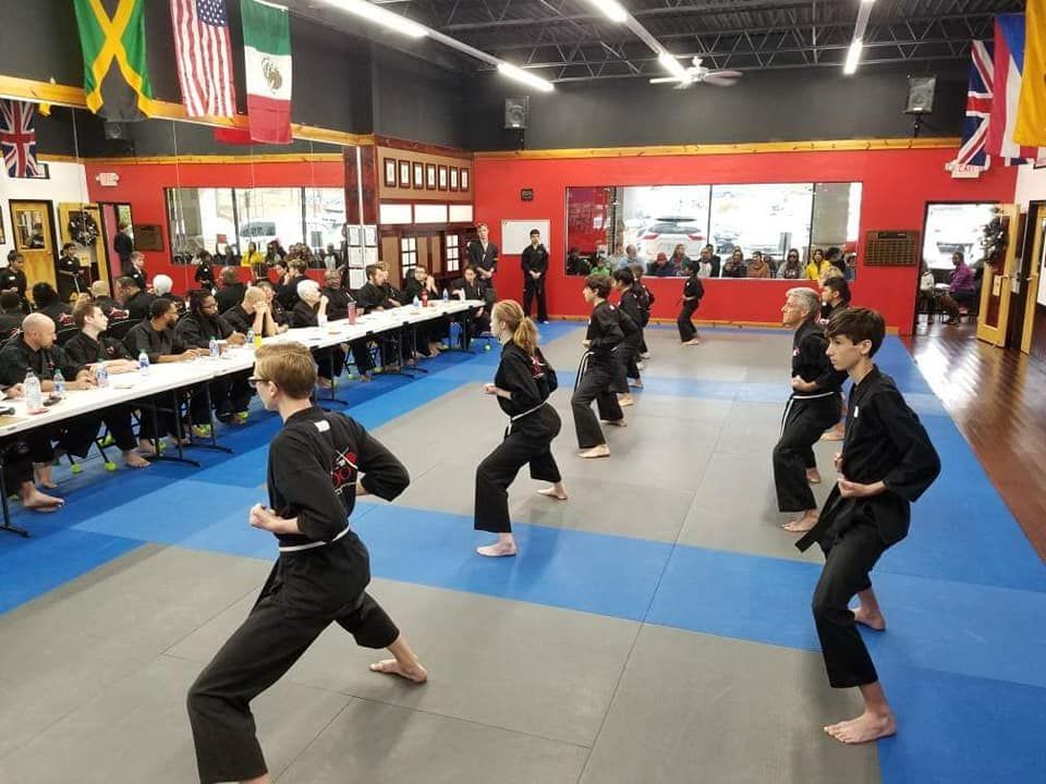 a group of people are practicing martial arts in a gym