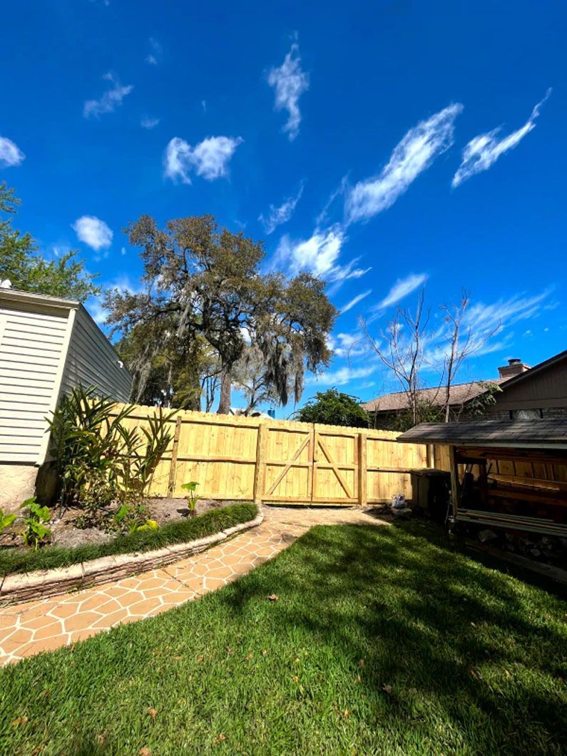 There is a wooden fence in the backyard of a house.