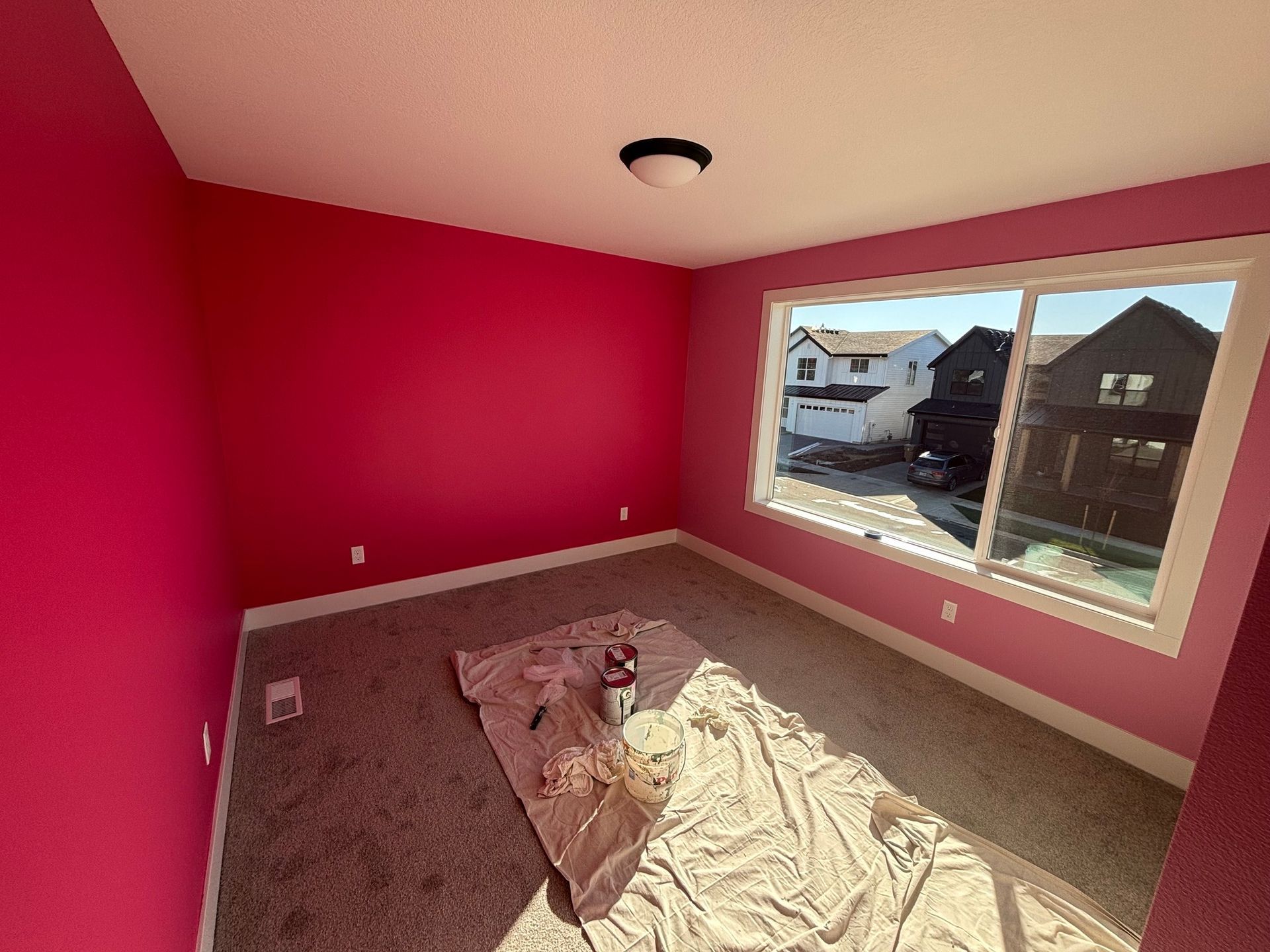 A room with pink walls and a large window.
