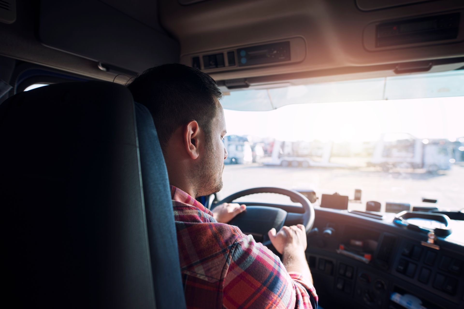 A man is sitting in the driver 's seat of a semi truck.